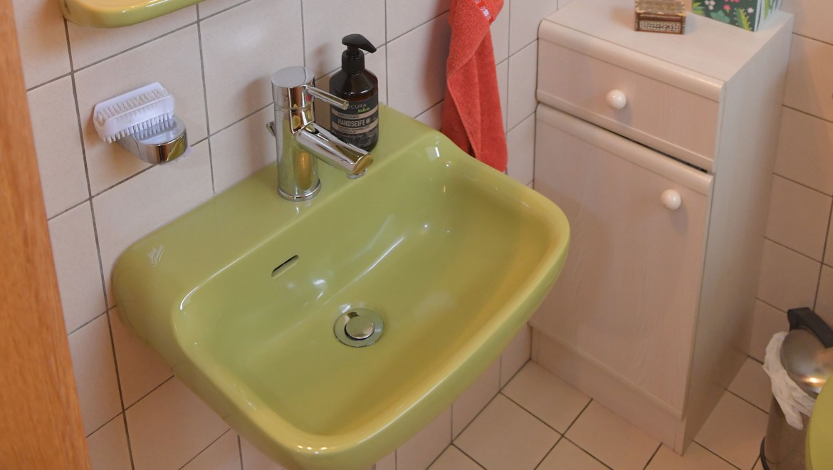 The guest bathroom with a small cabinet and washbasin